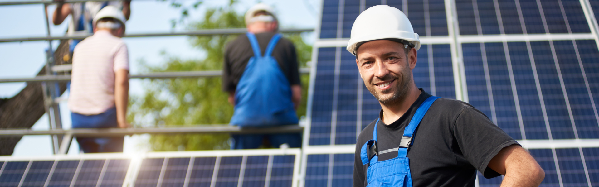 Portrait of smiling successful engineer technician standing in front of unfinished high exterior solar panel